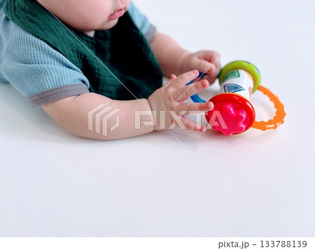 ベビーマットの上でおもちゃを見つめるハイハイ赤ちゃん 133788139