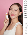 Beauty Product. Young woman holding a dropper bottle of serum with a bright smile. 133788190