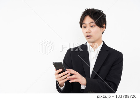 白い背景でスマホを操作する若いビジネスマン 133788720