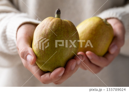 Fresh pear holding by woman hand 133789024