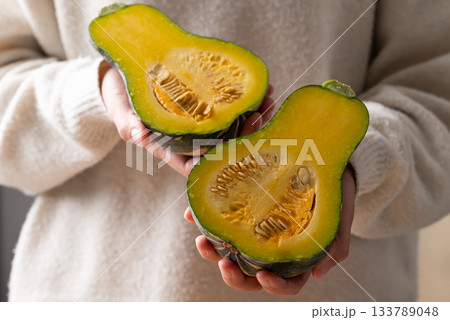 Half green butternut squash pumpkin holding by woman hand Half green butternut squash pumpkin holding by woman hand 133789048