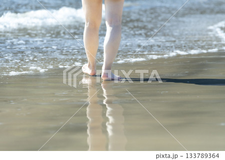 波打ち際で歩く女性　歩く　サンセット　夏の日　新しい日々　ビーチ　アイランド　トラベル　旅行 133789364