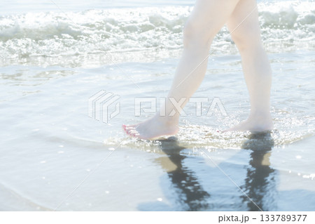 波打ち際で歩く女性　歩く　サンセット　夏の日　新しい日々　ビーチ　アイランド　トラベル　旅行 133789377