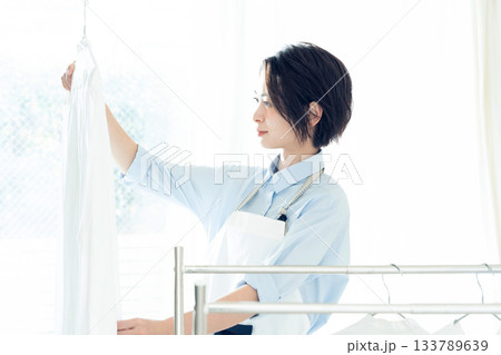 洗濯物を干す若い女性 133789639