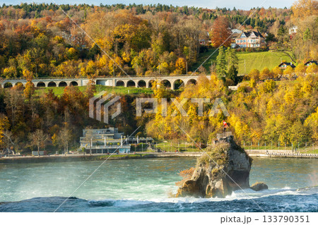 秋のラインの滝の遊歩道と色とりどりの木々。スイス、シャフハウゼン州ノイハウゼン 133790351