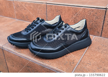 Elegant black leather womens shoes blank product for branding displayed. New casual female sneakers no-brand footwear e-commerce. No logo product 133790622