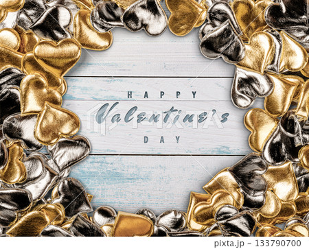 Elegant Valentine's Day Card Featuring Gold and Silver Hearts on Wooden Background 133790700