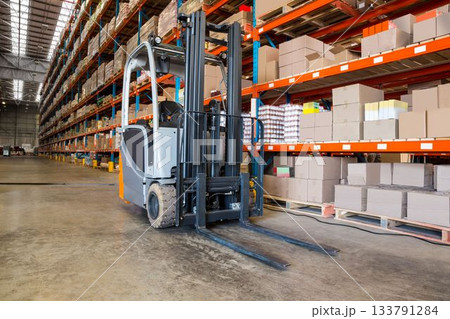 Forklift by rack in factory 133791284
