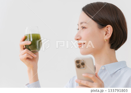 青汁とスマホを持つ女性 133791803