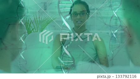 Asian woman in sleeveless blouse leading biotech discussion in office lounge, with DNA graphics Asian woman in sleeveless blouse leading biotech discussion in office lounge, with DNA graphics 133792116