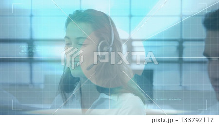 Speaking female call center agent handling customer request in open office, with headset mic Speaking female call center agent handling customer request in open office, with headset mic 133792117