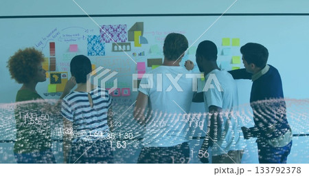 Collaborating five colleagues using whiteboard with sticky notes, charts and data overlay in office 133792378