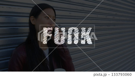 Asian woman in red jacket holding coffee cup using smartphone by storefront shutter, copy space 133793060