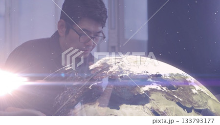 Leaning mature Asian man observing holographic Earth globe projection in office, with keyboard Leaning mature Asian man observing holographic Earth globe projection in office, with keyboard 133793177
