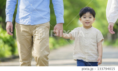 新緑の並木道を歩く3人家族 133794015