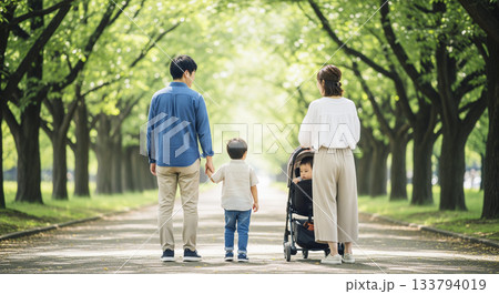 新緑の並木道を歩く4人家族の後ろ姿 133794019