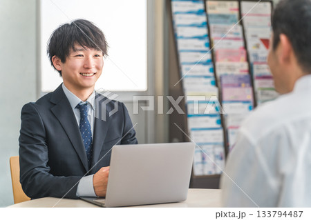 ショールーム・商談スペースで接客する若いアジア人ビジネスマンと女性客 133794487