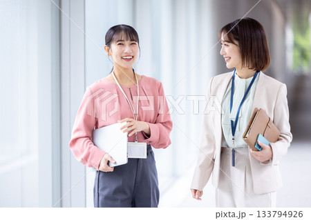 ビジネス　会話をしながら通路を歩いている女性 133794926