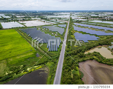 Aerial view drone shot scenic landscape of a road passing through a solar farm in Thailand 133795034