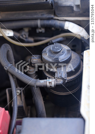 Closeup shot of a car oil filter pot, showcasing its construction and role in maintaining engine performance and lubrication efficiency Closeup shot of a car oil filter pot, showcasing its construction and role in maintaining engine performance and lubrication efficiency 133795044