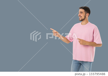 Man dressed casually in a pink shirt happily gestures to the side Man dressed casually in a pink shirt happily gestures to the side 133795486