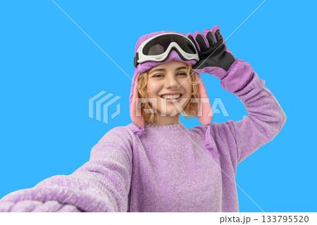 Woman wearing pink and purple ski gear smiles and poses Woman wearing pink and purple ski gear smiles and poses 133795520