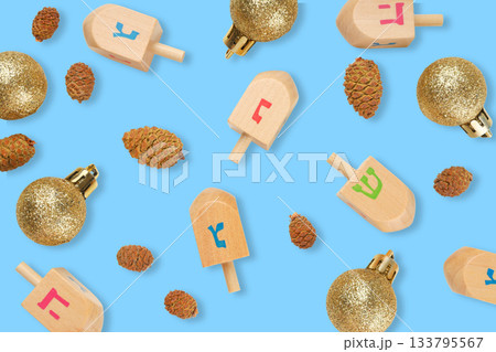 Hanukkah, dreidels and glitter ornaments with pinecones on blue Hanukkah, dreidels and glitter ornaments with pinecones on blue 133795567