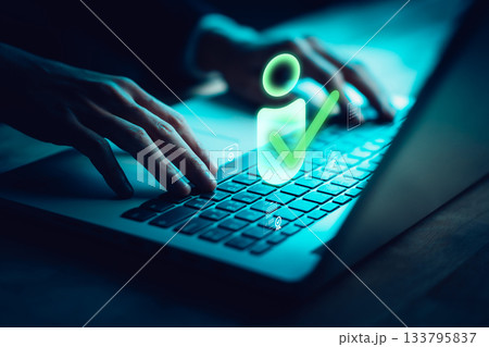 Hands typing on laptop with glowing user checkmark icon, representing digital identity verification, online authentication, secure login, data protection, or access approval system. Hands typing on laptop with glowing user checkmark icon, representing digital identity verification, online authentication, secure login, data protection, or access approval system. 133795837