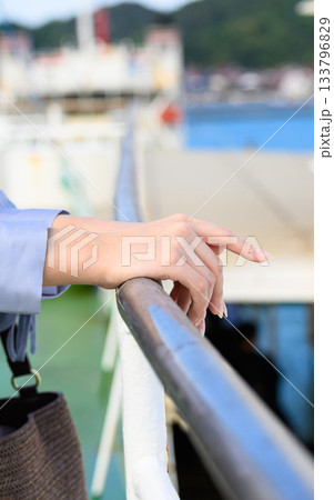 フェリーの手すりに触れる女性の手元と出航の景色 フェリーの手すりに触れる女性の手元と出航の景色 133796829
