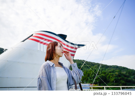 フェリーのファンネルを背景に佇む若い女性と青空 フェリーのファンネルを背景に佇む若い女性と青空 133796845