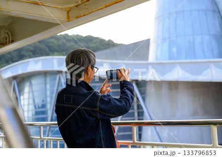 隠岐の島へ向かうフェリーでスマートフォンで景色を撮影するシニア女性 隠岐の島へ向かうフェリーでスマートフォンで景色を撮影するシニア女性 133796853