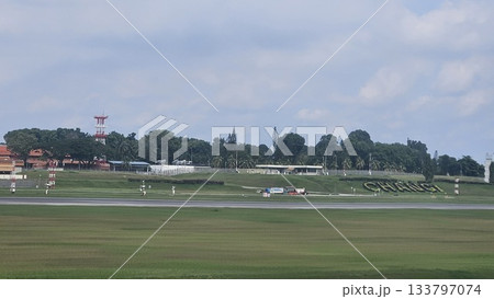 Changi Airport lush greenery spells its name beside a busy runway 133797074
