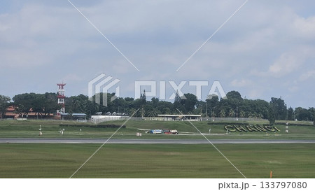 Changi Airport lush greenery spells its name beside a busy runway 133797080