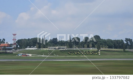 Changi Airport lush greenery spells its name beside a busy runway 133797082