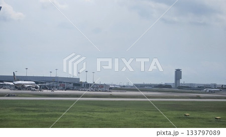 Changi Airport lush greenery spells its name beside a busy runway 133797089