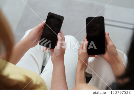 Social Media Connection. Two friends holding smartphones with blank screens. 133797528