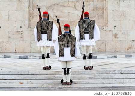 Three members of the Presidential Guard soldiers (evzones) in the city center of the Greek capital, Athens, Greece. Concept of historical traditional ceremony of elite military. 133798630