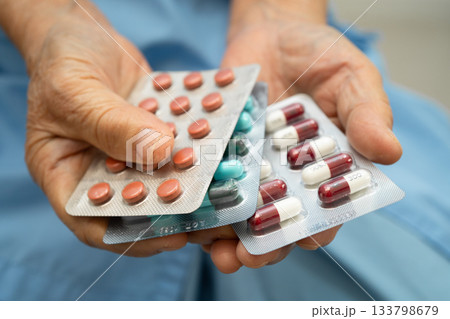Asian elderly woman holding pill drug in hand, strong healthy medical. Asian elderly woman holding pill drug in hand, strong healthy medical. 133798679
