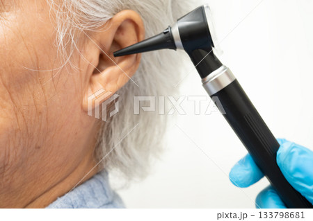Otolaryngologist or ENT physician doctor examining senior patient ear with otoscope, hearing loss problem. Otolaryngologist or ENT physician doctor examining senior patient ear with otoscope, hearing loss problem. 133798681