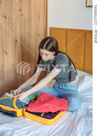 Woman preparing suitcase for travel packing vacation 133798691