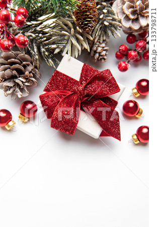 Christmas giftbox with red ribbon and winter holiday decorations Christmas giftbox with red ribbon and winter holiday decorations 133798711