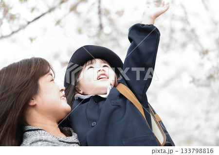 桜と入園式を迎えた3歳の女の子と母親 133798816