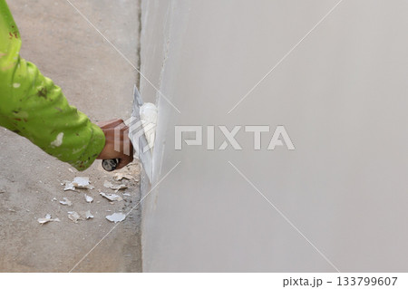 Hand of worker with wall plastering tools renovating house. Hand of worker with wall plastering tools renovating house. 133799607