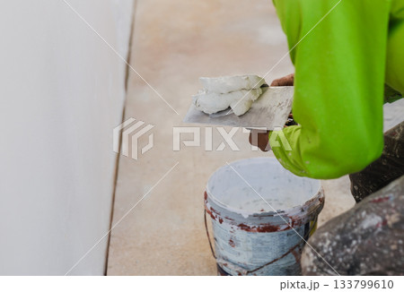 Worker with wall plastering tools renovating house. Worker with wall plastering tools renovating house. 133799610