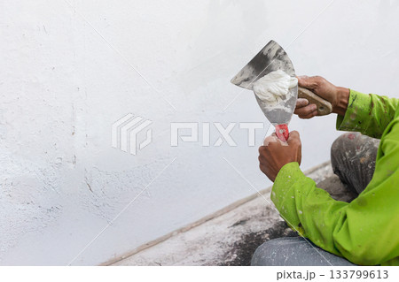 Painter's hand puttied wall using A paint trowel. Painter's hand puttied wall using A paint trowel. 133799613