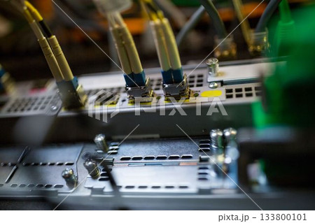Flat design is showing LC fiber optic cables connecting into network patch panel chassis in rack Flat design is showing LC fiber optic cables connecting into network patch panel chassis in rack 133800101