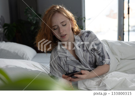 an adult woman is thoroughly going through her recent messages on her mobile phone an adult woman is thoroughly going through her recent messages on her mobile phone 133800315