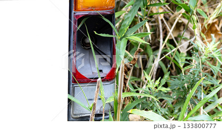山林放置されているテールランプが割れている放置自動車 133800777