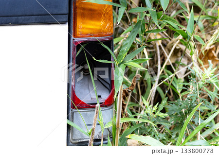 山林放置されているテールランプが割れている放置自動車 133800778
