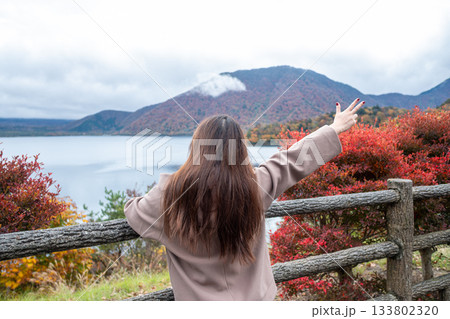 Motosuko lake, Fujikawaguchiko, Yamanashi, Japan, Woman enjoying autumn view at lake with colorful foliage and mountains 133802320